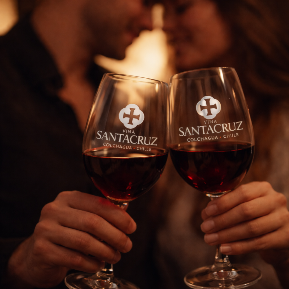 Pareja brindando con copas de vino de Viña Santa Cruz en un ambiente cálido y romántico
